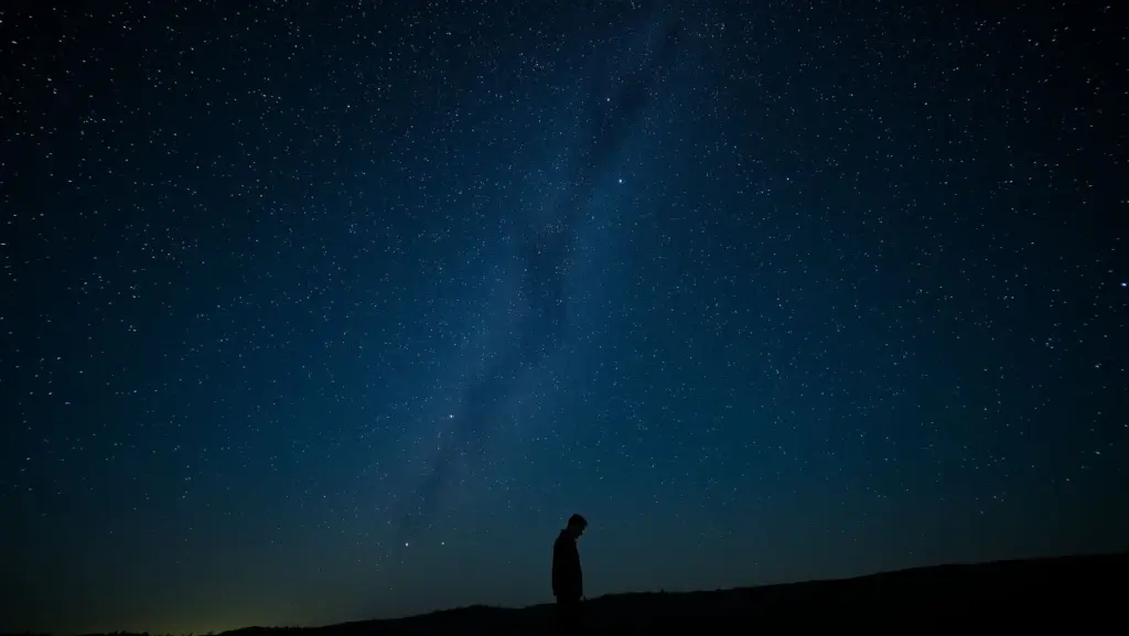 Man alone under stars, whispering last verse, feeling epic sadness