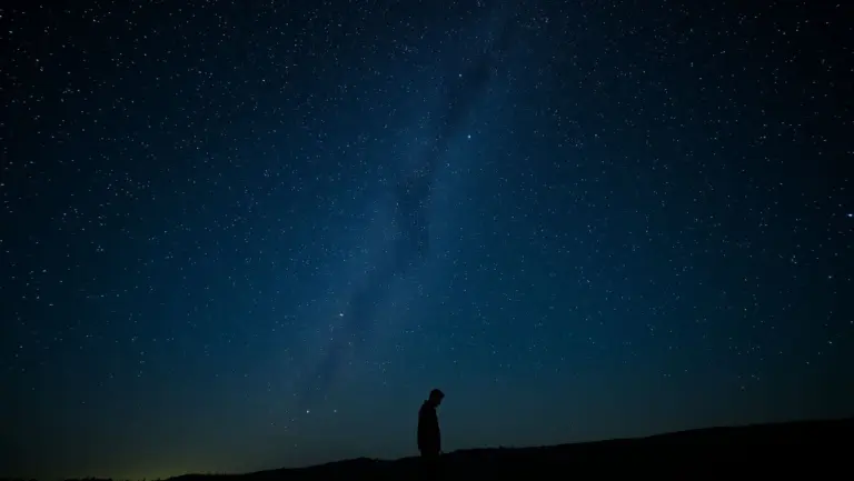 Man alone under stars, whispering last verse, feeling epic sadness