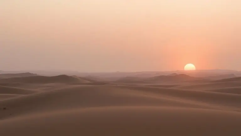 Sunrise over a desert landscape with pastel colors and soft light.
