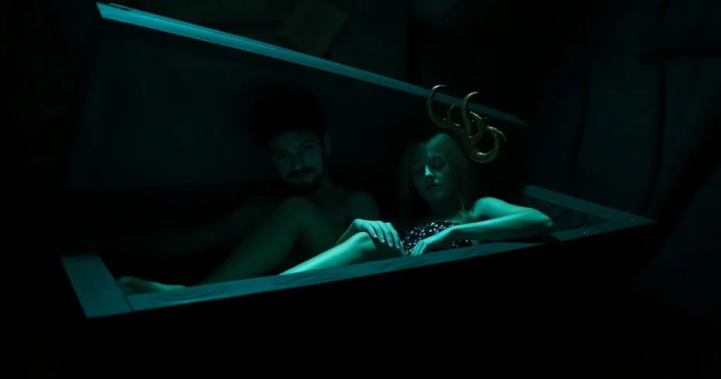 Andy and Leyley with a creepy coffin in a dark atmosphere.