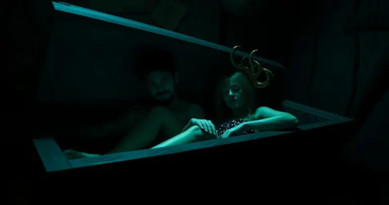 Andy and Leyley with a creepy coffin in a dark atmosphere.