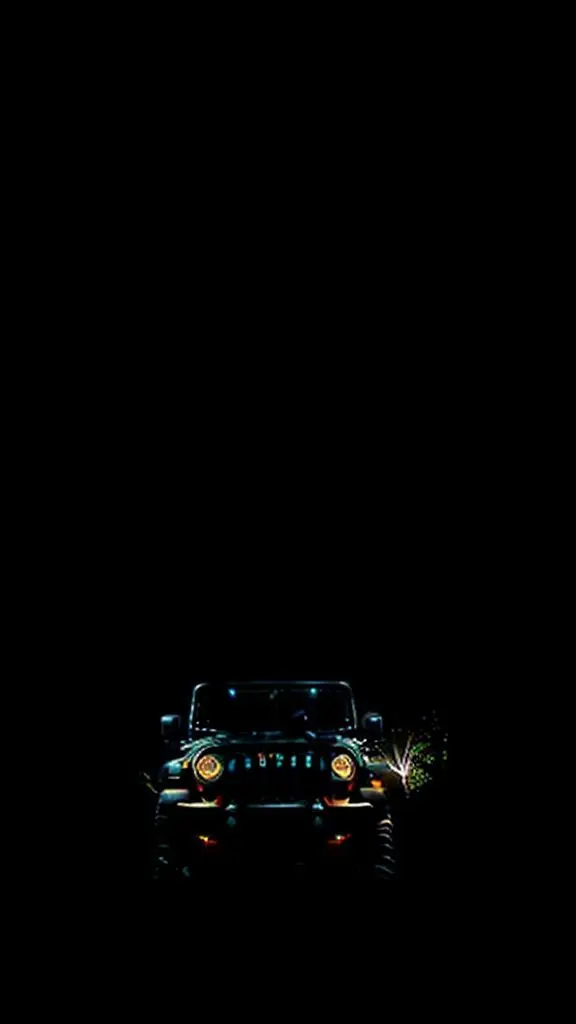 Jeep driving at night through trees.