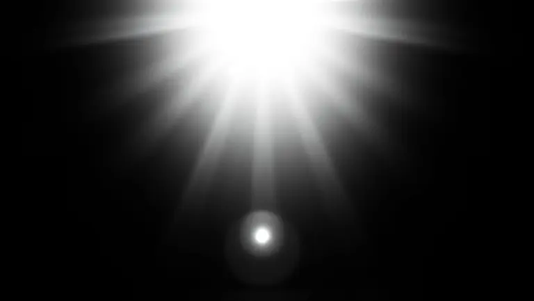 Grainy black and white close-up of a lightbulb resembling the sun.