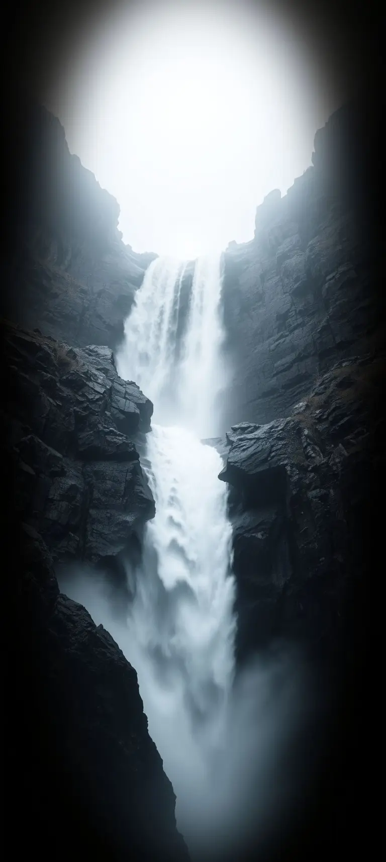 Monochromatic waterfall with soft lighting and dark edges.