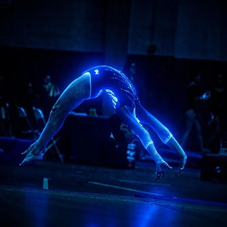 Woman in glowing blue LED leotard at night in the rain