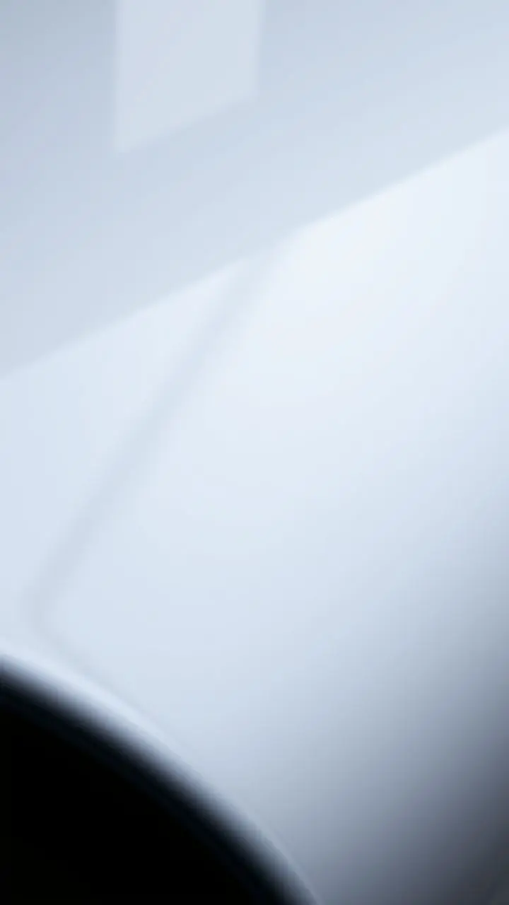 Close-up of a smooth, reflective surface with light highlights and shadows.