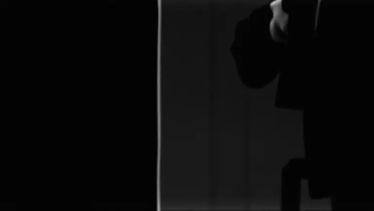 Man with no reflection, grainy black and white, square format.