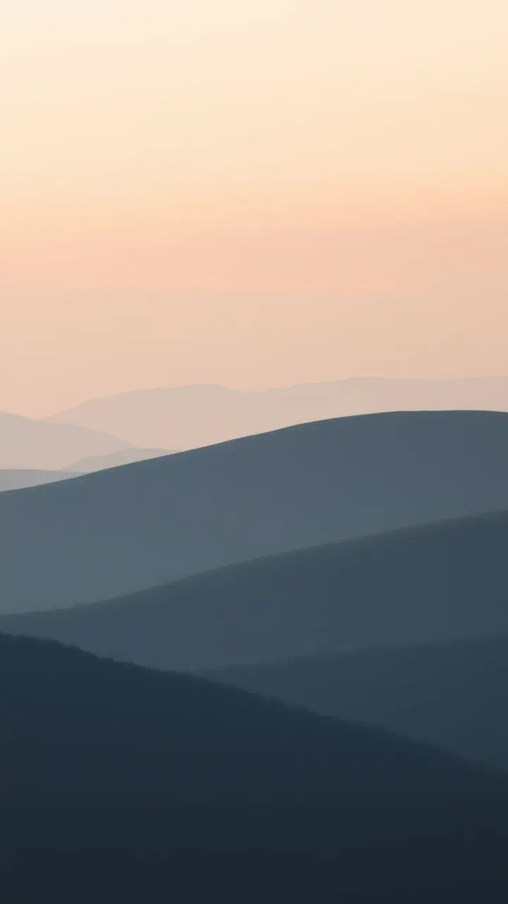 Rolling hills at dawn with pastel sky and mist.