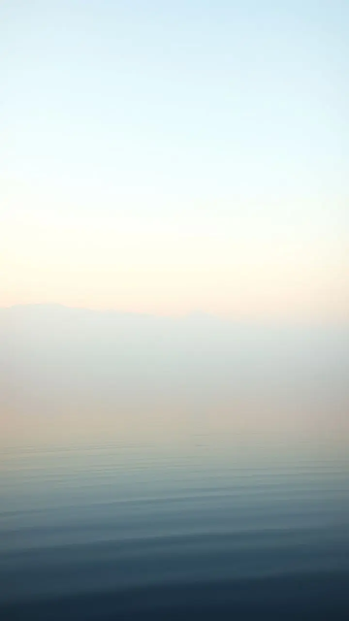 Dawn landscape with a calm lake and mist.