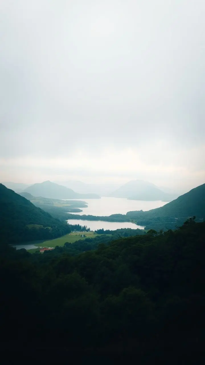 Serene landscape with a lake, greenery, mountains, and soft natural vignetting.